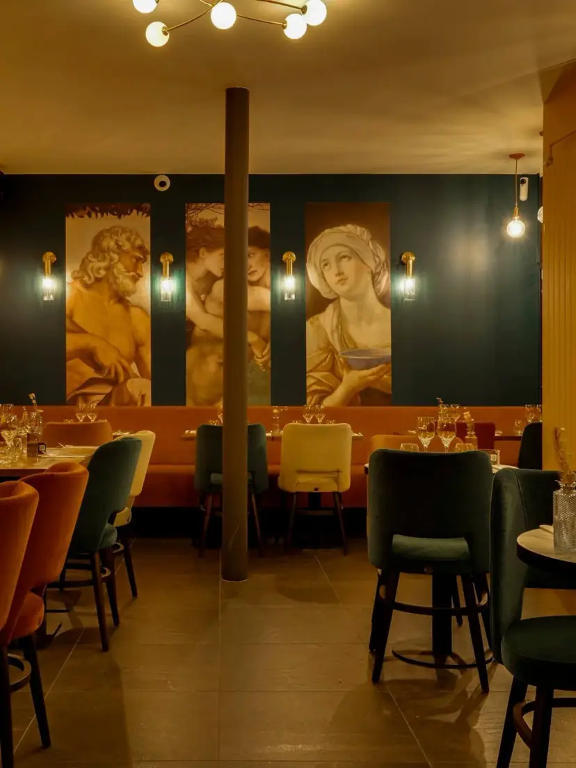 La salle de Melagodo : banquettes, lampes dorées et fresques